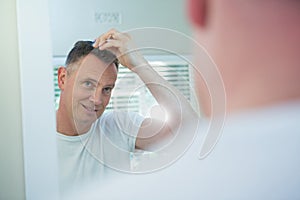 Man combing his hair in bathroom