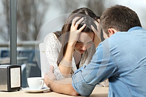 Man comforting a sad depressed girl photo