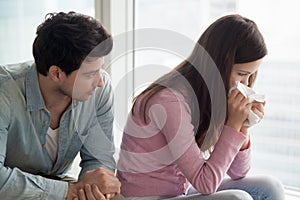Man comforting upset woman crying, guy consoling weeping young l