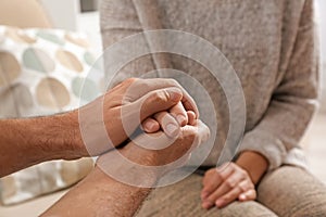 Man comforting woman, closeup of hands.