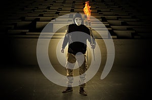 Man coming with burning flambeau from the maze concept