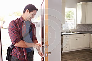 Man Coming Home From Work And Opening Door Of Apartment