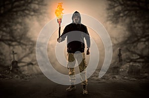 Man coming out from a thicket with burning flambeau