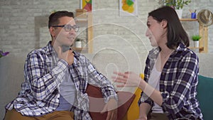 A man communicates with a young woman sitting on the couch uses speech aid problems with ligaments