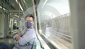 Man commuter with face mask on inside a moving subway train