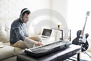 Man composing a song with electric piano photo