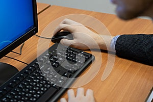 man at the computer, hand on the mouse