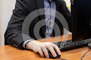 man at the computer, hand on the mouse