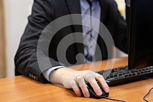 man at the computer, hand on the mouse