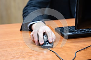 man at the computer, hand on the mouse