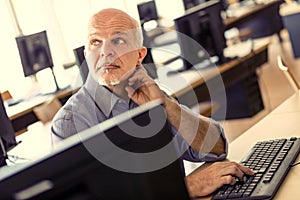 Man at computer listens to colleague`s opinion
