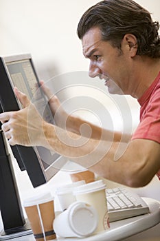 Man in computer room grabbing his computer