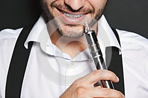 Man with concealed identity smoking a vape