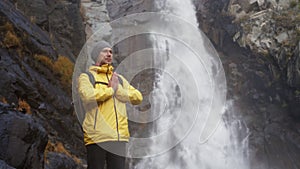 Man concentrates on breathing, relaxes near waterfall