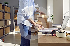 Man Conducting Inventory At Online Shop Warehouse Or Postal Office