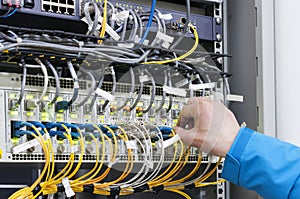 Man connecting network cables to switches