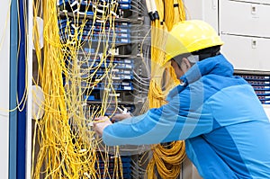 Man connecting network cables to switches in the computer room