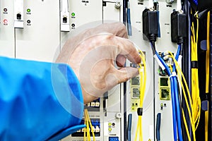 Man connecting network cables to switches in the computer room