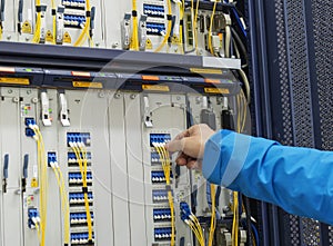 Man connecting network cables to switches in the computer room