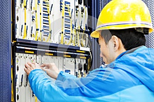 Man connecting network cables to switches in the computer room