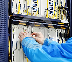 Man connecting network cables to switches in the computer room