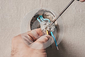 Man connects an electric light switch to the wall