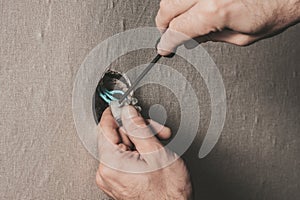 Man connects an electrical light switch to the wall - electrical work