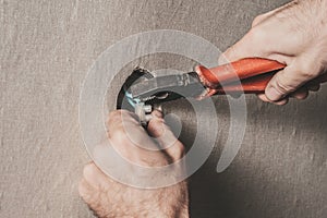 Man connects an electrical light switch to the wall - electrical work