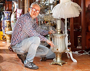 man connoisseur in interior of antique store