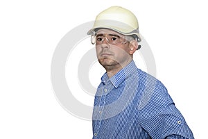 A man in a construction helmet and a blue shirt on a white isolated background. Looking into the distance. Brigadier. Builder.