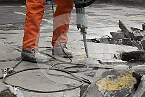 Man at construction site demolishing asphalt