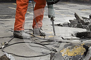 Man at construction site demolishing asphalt photo