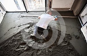 Man construction worker screeding floor in apartment.