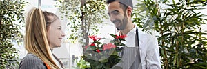 Man consultant gives flowers in pot to his colleague, show liking for her