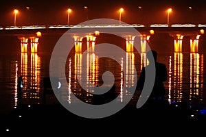 Man contemplating bridge lights