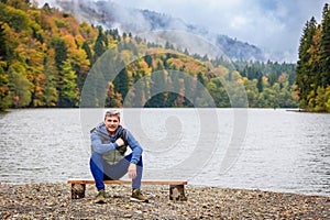 Man contemplating nature near the shore of a lake in the mountains