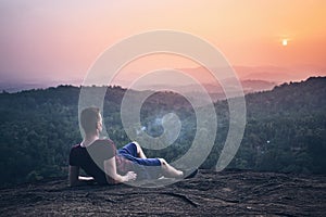 Man contemplation on top of rock