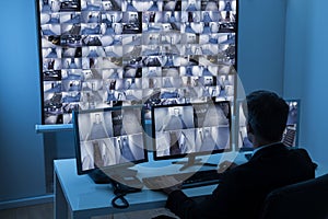 Man in control room monitoring cctv footage