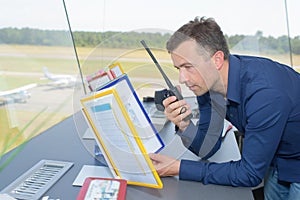 Man in control tower talking into two way radio