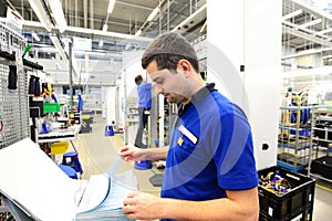 man controlled assembly instructions, in the background mounted a woman an industrial machine