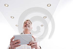 Man Controlling Lighting With App On Digital Tablet photo