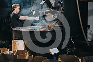 Man controlling process of roasting coffee beans