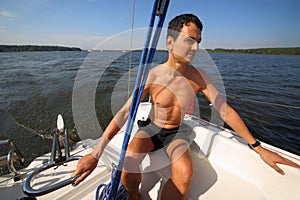Man controls boat using tiller at stern during photo