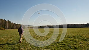 A man controls a drone in field