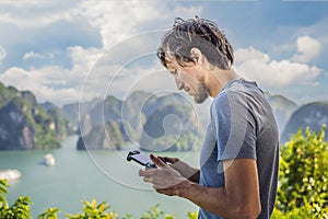 Man controls a drone in Halong Bay. Vietnam. Travel to Asia, happiness emotion, summer holiday concept. Picturesque sea