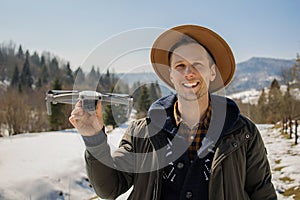 Man controls the flying drones in snowy forest winter. Adventurous winter holiday