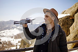 Man controls the flying drones in snowy forest winter. Adventurous winter holiday