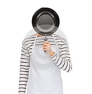 Man or cook in apron hiding face behind frying pan