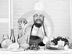 Man cook hat and apron hold broccoli. Healthy nutrition concept. Bearded professional chef cooking healthy food. Healthy