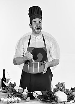 Man in cook hat and apron mixes in pot